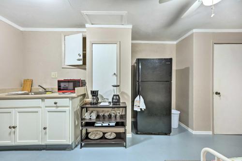a kitchen with a black refrigerator and white cabinets at 4 Mi to Beaches Cozy Studio in Port Richey! in Port Richey