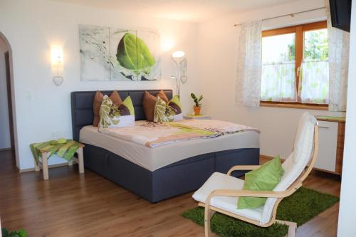 ein Schlafzimmer mit einem Bett und zwei Stühlen darin in der Unterkunft Ferienwohnung Weitblick in Hochpillberg