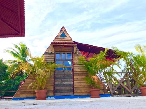 una pequeña casa de madera con palmeras delante en Tinyhouse samaná 