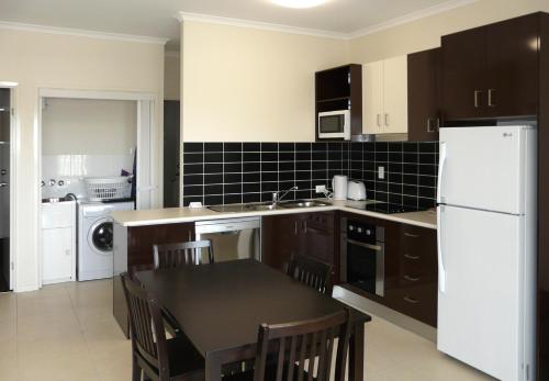 a kitchen with a refrigerator, stove, sink and a microwave at Property Vine - Monterey Moranbah, formerly Direct Hotels - Monterey Moranbah in Moranbah