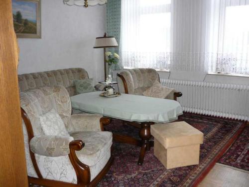 - un salon avec un canapé, une table et des chaises dans l'établissement Ferienwohnung Oehlert, à Großsolt