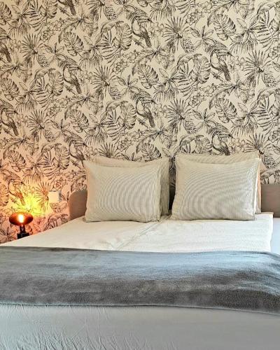 a bed with two pillows in a bedroom with a wallpaper at Atlantic View Maspalomas in Maspalomas