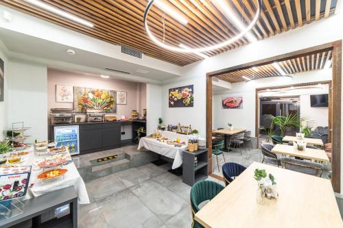 a restaurant with tables and chairs and a kitchen at Campeador Inn in Cluj-Napoca