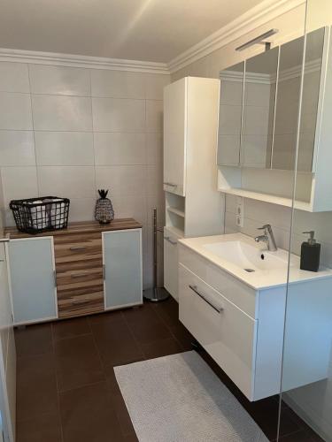 a white bathroom with a sink and a mirror at Appartement Petra in Bruck an der Großglocknerstraße