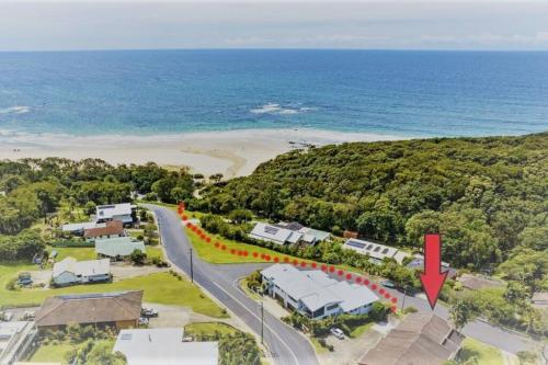 an aerial view of a house with a road and the ocean at THE DAVEY Luxury home in Nambucca Heads