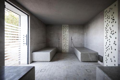 a bathroom with two benches and a large window at ADLER Spa Resort SICILIA in Siculiana