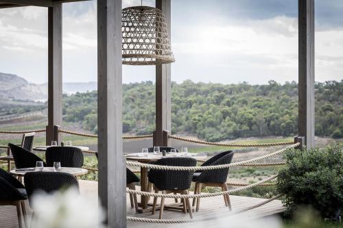 a patio with tables and chairs and a view of the mountains at ADLER Spa Resort SICILIA in Siculiana