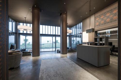 a lobby with a reception desk and large windows at ADLER Spa Resort SICILIA in Siculiana