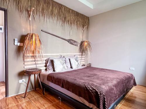 een slaapkamer met een bed en twee hangplanten bij Sea Dreamer Beachfront Apartments in Phuket
