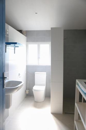 une salle de bain blanche avec des toilettes et un lavabo dans l'établissement Glamping Place de la Famille, à Jayac