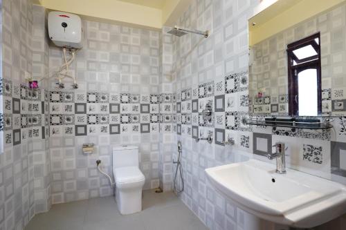 a white bathroom with a sink and a toilet at Hotel White Lotus Gangtok in Gangtok