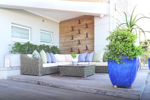 a patio with a couch and a blue vase at Beach Villa Wilderness in Wilderness
