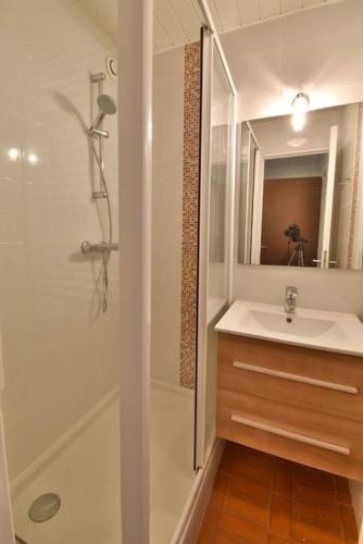 une salle de bain blanche avec un lavabo et une douche dans l'établissement CONFORTABLE APPARTEMENT GRANDE TERRASSE PISCINE PARKING CLIM, au Cap d'Agde