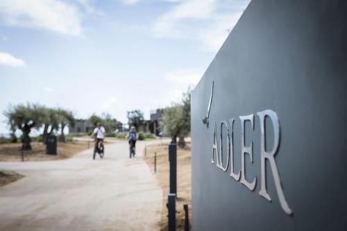 two people riding bikes down a dirt road at ADLER Spa Resort SICILIA in Siculiana