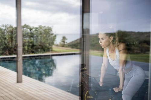 a woman looking out the window of a house at ADLER Spa Resort SICILIA in Siculiana
