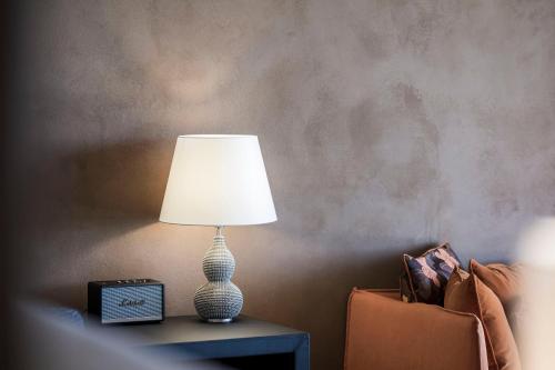 a lamp sitting on a table next to a couch at ADLER Spa Resort SICILIA in Siculiana