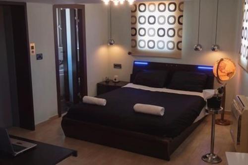 sypialnia z dużym czarnym łóżkiem z 2 ręcznikami w obiekcie Deluxe οροφοδιαμέρισμα με υδρομασάζ κ' ταρατσόκηπο w mieście Patras