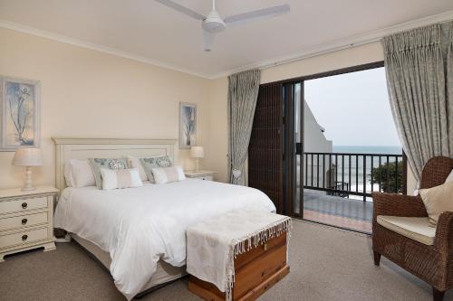 een slaapkamer met een groot bed en een balkon bij Martinique 18 in Ballito