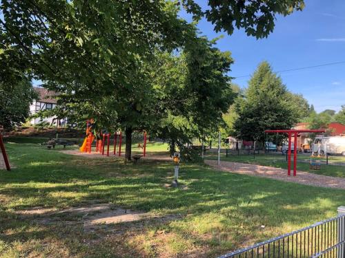 a park with a playground with orange structures at Ferienwohnung Wolff am Natursteig Sieg und Westerwald in Pracht