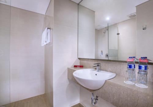 a white bathroom with a sink and a mirror at favehotel Tanah Abang - Cideng in Jakarta