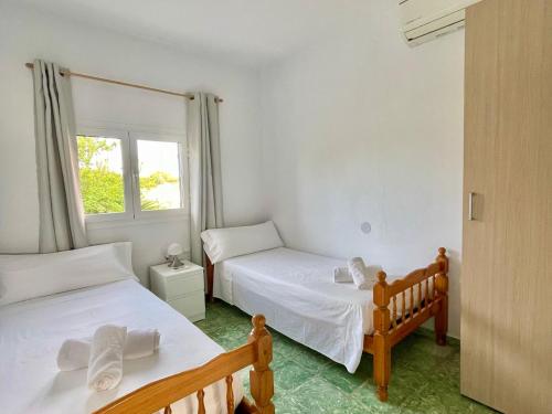 a bedroom with two beds and a window at Casa frente al lago in La Savina