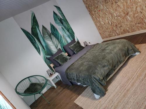 ein Schlafzimmer mit einem Bett mit einer grünen Tagesdecke und einem Stuhl in der Unterkunft Sélénite, Chaleureuse et Cocooning. in Braux