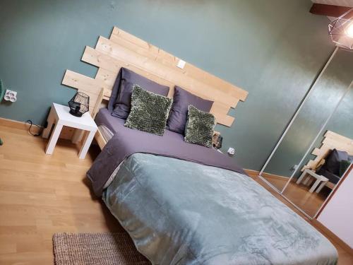 1 dormitorio con 1 cama grande y cabecero de madera en Sélénite, Chaleureuse et Cocooning. en Braux
