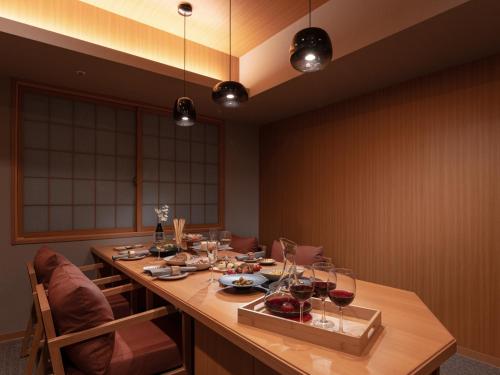 uma sala de jantar com uma longa mesa com copos de vinho em MIMARU SUITES Tokyo ASAKUSA em Tóquio
