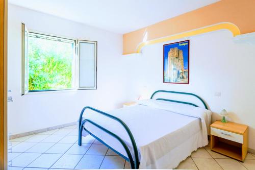 a white bedroom with a bed and a window at Orosei RE - Villa Osala - 800 m dal mare in Orosei