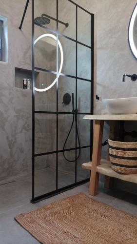 a glass shower door in a bathroom with a sink at Pyrrichos Stone House in Pírrikhos