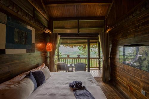 a bedroom with a bed and a balcony with a television at Sapa Jade Hill Resort & Spa in Sa Pa