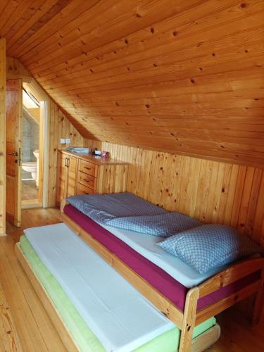 Cama en habitación con techo de madera en APARTMA-SPA NATURA, en Sveti Jurij ob Ščavnici