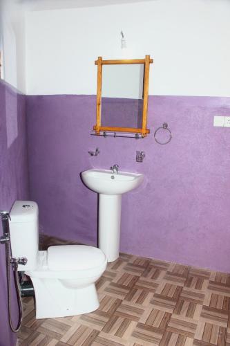 a bathroom with a white toilet and a sink at Seasons Four Mini Jungle Cabana in Matara