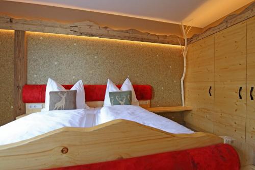 a bedroom with a large bed with white sheets and pillows at Naturpension Max-Hütte in Breitenbrunn