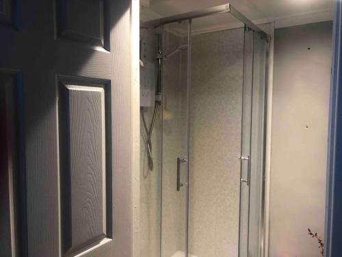 a shower in a bathroom with a glass door at Mac studio : private room, en-suite & own access in Belfast