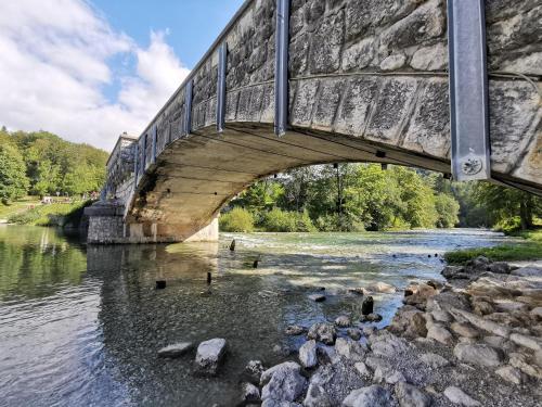 a bridge over a river with rocks in the water at Bohinj, Metka - vacation house Pri Metki in Bohinj
