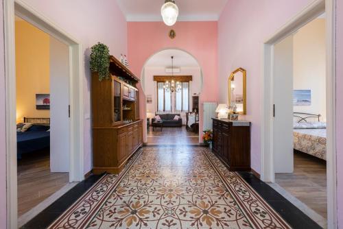 einen Flur mit einem Zimmer mit rosa Wänden in der Unterkunft Villa Perondi in Lido di Camaiore