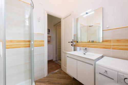 ein weißes Badezimmer mit einem Waschbecken und einem Spiegel in der Unterkunft Villa Perondi in Lido di Camaiore