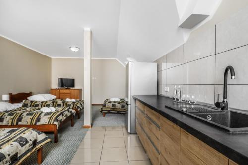 a bathroom with two beds and a sink in a room at Holiday Stary Folwark in Suwałki