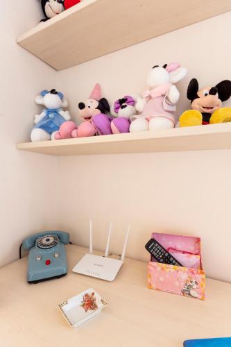 a shelf with stuffed animals and a book on a desk at Le Pendici Casa Vacanze in Boscotrecase