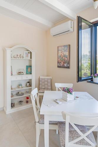 a white dining room with a white table and chairs at Le Pendici Casa Vacanze in Boscotrecase