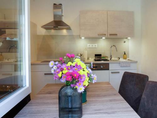 un jarrón de flores sentado en una mesa en una cocina en Alpok-Spirit Apartment – Velem en Velem