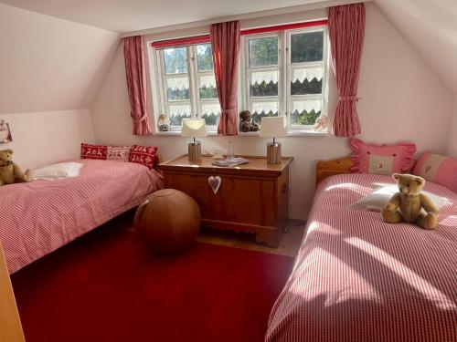 a bedroom with two beds and a teddy bear sitting on the bed at Ferienhaus unter Reet im Heidedorf Sankt Dionys bei Lüneburg in Sankt Dionys