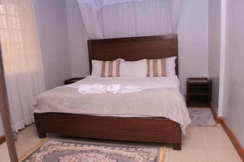 ein Schlafzimmer mit einem Bett mit zwei Handtüchern darauf in der Unterkunft BIDA FURNISHED APARTMENTS in Naivasha