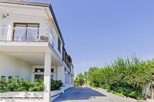 a white building with a balcony on a street at Le Pendici Casa Vacanze in Boscotrecase