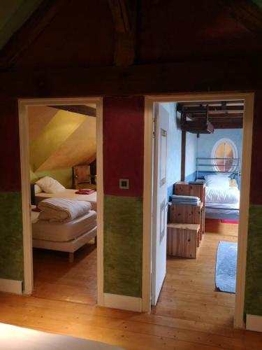 Cette chambre comprend 2 lits et une porte menant à une chambre. dans l'établissement GITE CHAUVRY 6 lits, à Chauvry