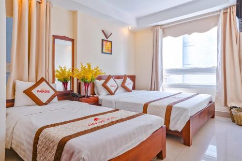 Habitación de hotel con 2 camas y ventana en Paradise Hotel, en Da Nang