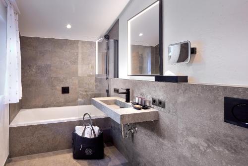 a bathroom with a sink and a bath tub at Chalet Gletscherblick in Sankt Anton am Arlberg