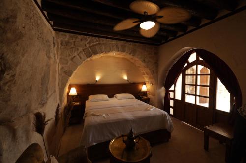 - une chambre avec un grand lit dans un mur en pierre dans l'établissement CEVHER KONAĞI, à Halfeti