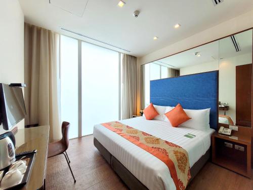 a hotel room with a large bed and a mirror at On 8 Sukhumvit Nana Bangkok by Compass Hospitality in Bangkok